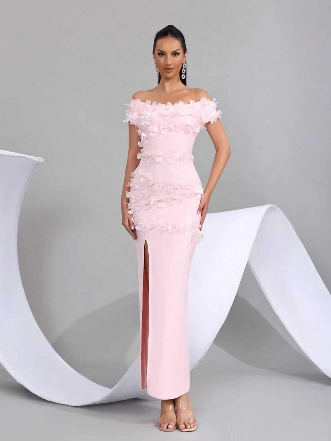 Woman wearing a pink off-shoulder evening gown with  floral details 
